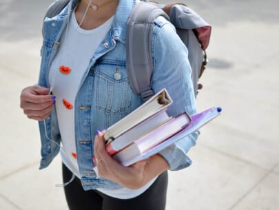 a person carrying books and a backpack