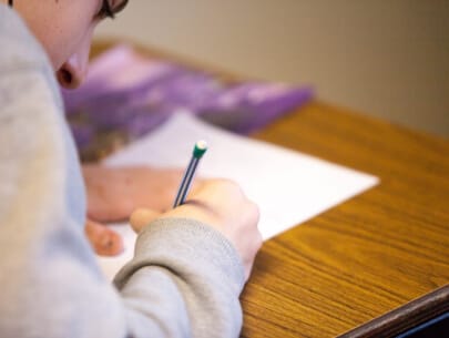 a person writing on a piece of paper