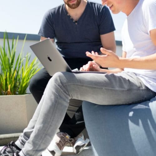 a person sitting on a bean bag with a laptop